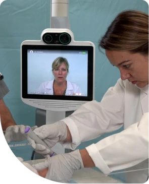 A doctor provides emergency care to a baby while on videocall with a doctor using a Teladoc Health's device