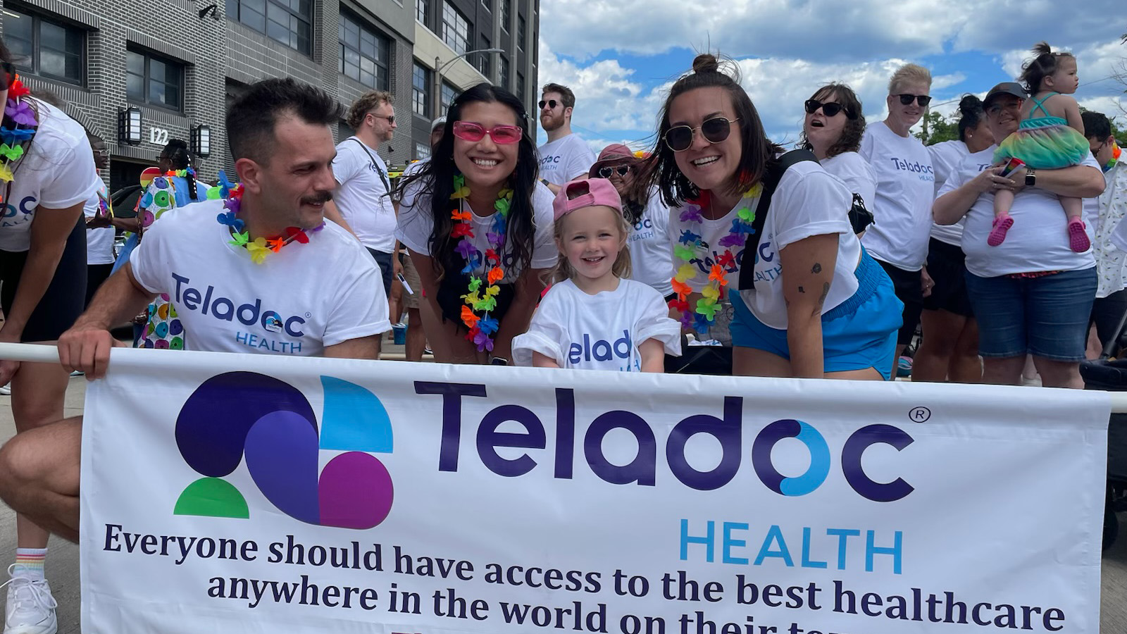 People standing behind a Teladoc Health banner