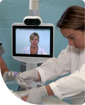 A doctor provides emergency care to a baby while on videocall with a doctor using a Teladoc Health's device