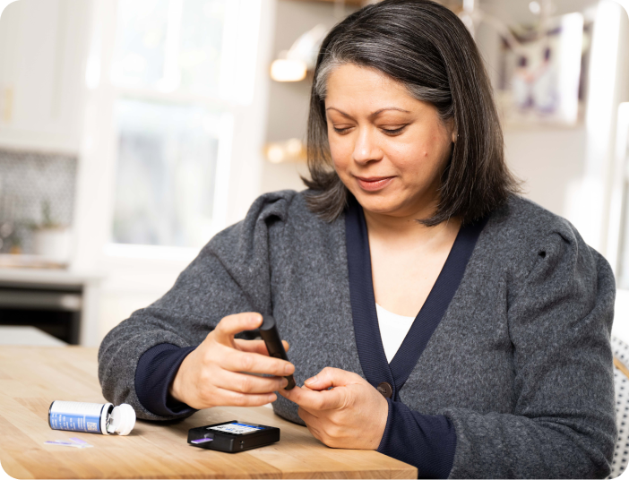 Woman checking blood sugar in kitchen