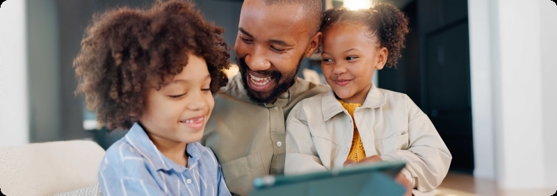 Father and his kids using a digital tablet in the living room.